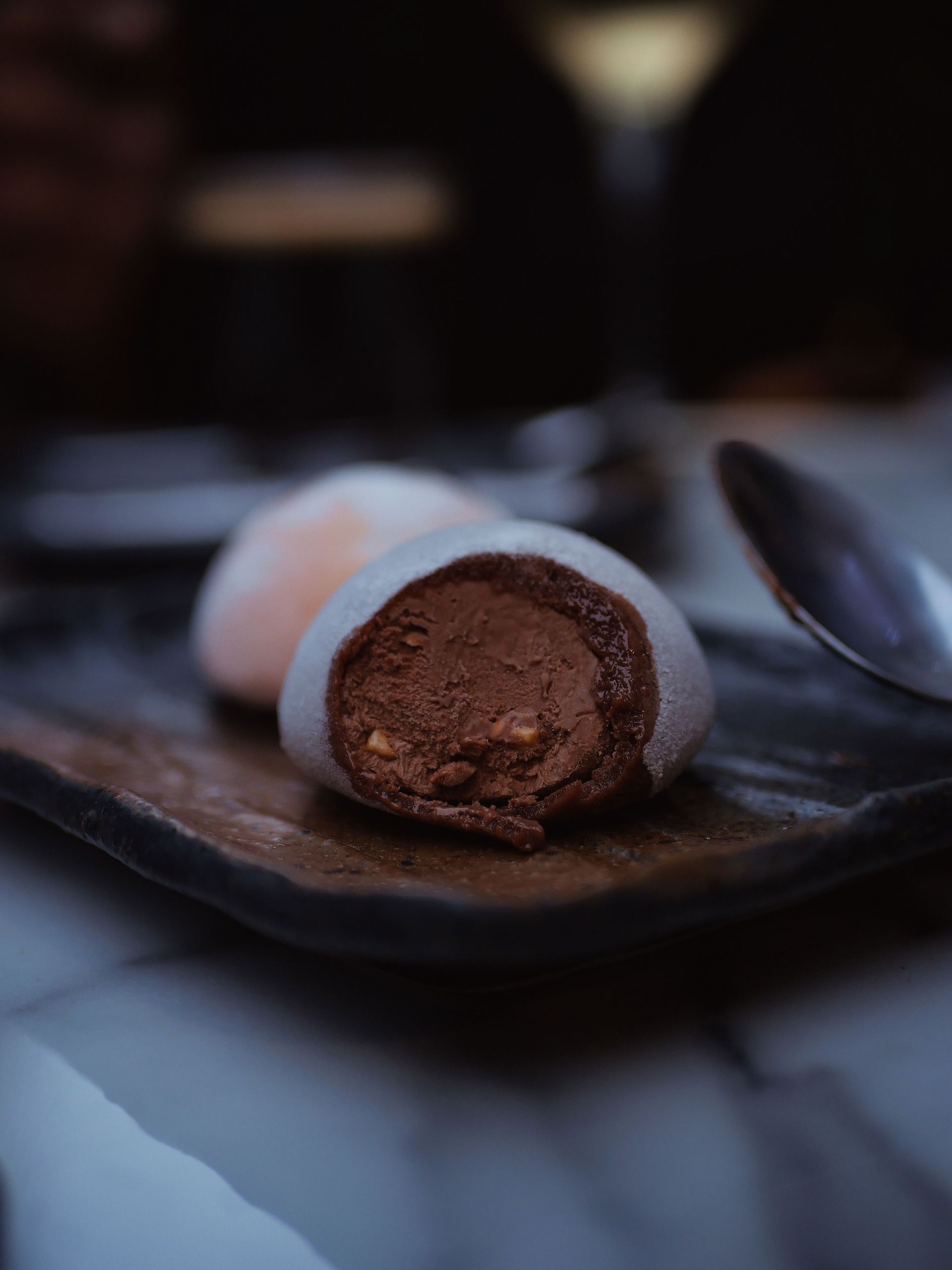 A delicious chocolate mochi close-up on a dark tray, perfect for dessert themes.